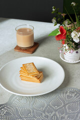 a glass of milk tea with biscuits on a plate