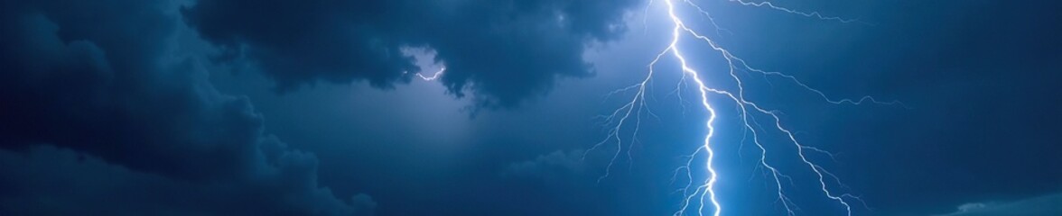 Dark grey clouds fill the night sky with flashes of electric light, lightning, heavy rain, stormy weather