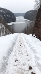 Snowy path overlooking frozen river valley