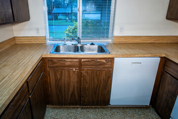 1970s vintage kitchen, dark brown cabinets, wood grain laminate counter tops, white walls and...