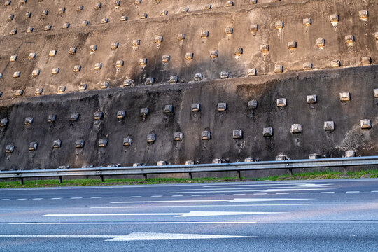 This image captures a reinforced slope stabilized with geogrid and anchors. The visible layers of geogrid provide structural support, preventing erosion and landslides. 