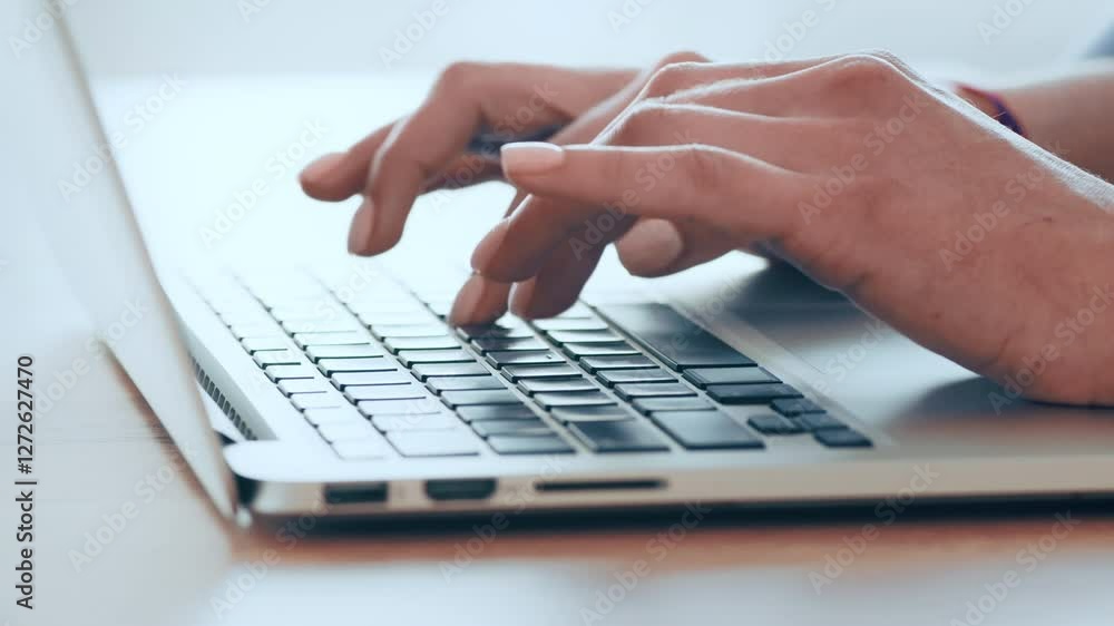 Poster a person types on a sleek laptop keyboard, focused on their work. natural light streams into the bri