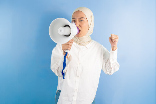 portrait of female holding megaphone shouted while clenching his fist