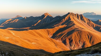 Naklejka premium Majestic Mountain Range at Sunset with Warm Golden Light
