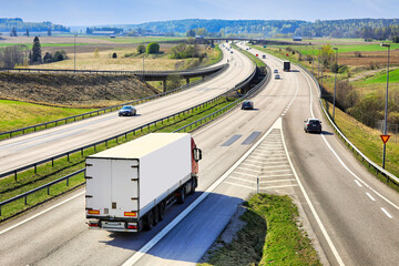 Motorway traffic with a heavy truck pulling semi trailer, rear view. 