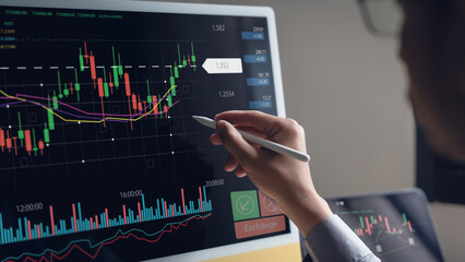 Businessman looks at stock market trading charts and analyzes investment opportunities.