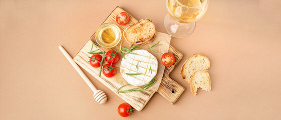 Wooden board with tasty baked Camembert cheese on brown background