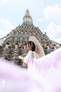 Woman in traditional Thai costumes at Wat Arun Ratchawararam (the Temple of Dawn) in Bangkok, Thailand.