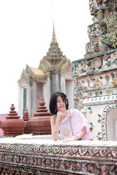 Young woman in traditional Thai costumes at Wat Arun  in Bangkok, Thailand.