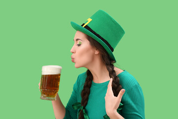 Young woman with beer on green background. St. Patrick's Day