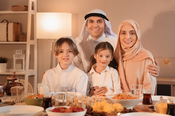 Happy Muslim family having dinner at home in evening. Ramadan celebration