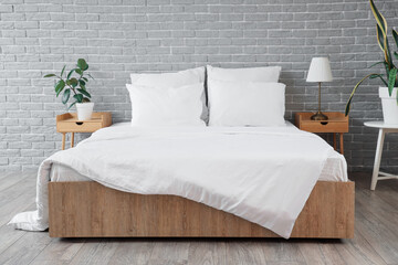White pillows with blanket on bed in modern bedroom interior