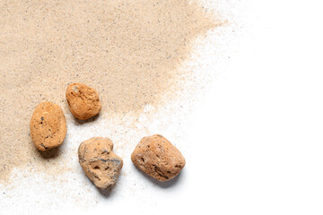 Light beach sand with stones on white background
