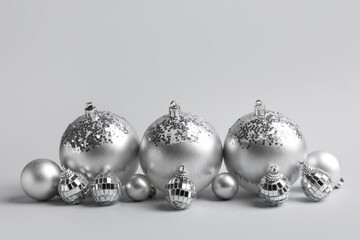 Silver Christmas baubles on grey background