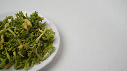 A collection of raw papaya flowers placed on a white plate with a white base and background (isolated white).