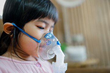 Girl using Oxygen breathing machine at home smile and surprice. Breathing device for asthma and...