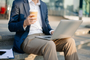 Modern businessman outdoors, using a tablet. Ideal for business, technology, and innovation themes.