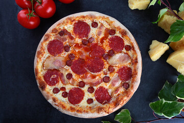 Hearty meat pizza. Pizza with meat ingredients: brisket, hunting sausages, bacon. Two types of sausage and bacon in meat pizza.