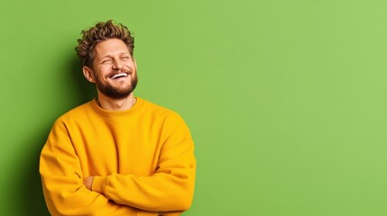 Fototapeta premium Man with beard in yellow sweater smiling against green background in a casual setting