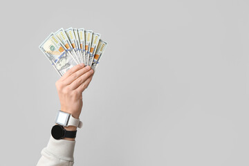 Man holding dollar banknotes on light background