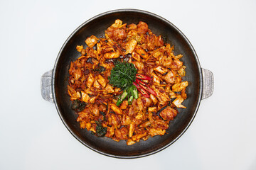 Stir-fried spicy pork with chili and parsley in a pan
