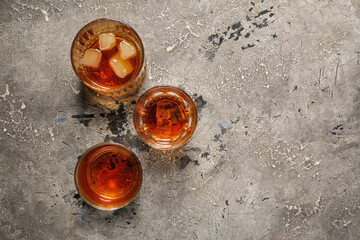 Glasses of cold rum on grey grunge background