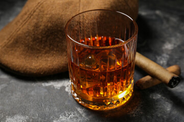Male cap, cigars and glass of cold rum on grey grunge background, closeup