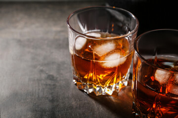 Glasses of cold rum on black grunge background, closeup