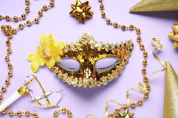 Beautiful golden carnival mask and beads on lilac background
