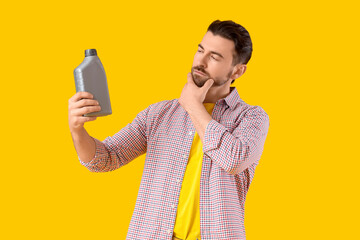 Thoughtful young man with canister on yellow background