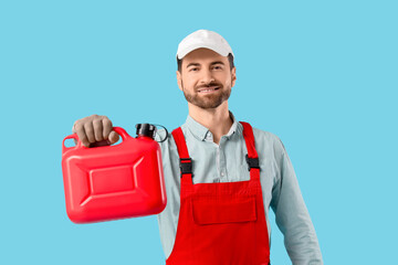 Male mechanic with canister on blue background