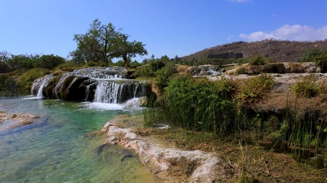 Wadi Darbat oasis, waterfalls, and natural spring with sparkling, clear water in Oman near Salalah