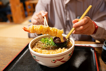 海老天蕎麦を食べる男性