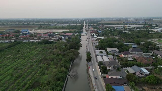 Drone footage of the Rangsit Prayunsak canal during a cloudy daytime in Pathum Thani, Thailand