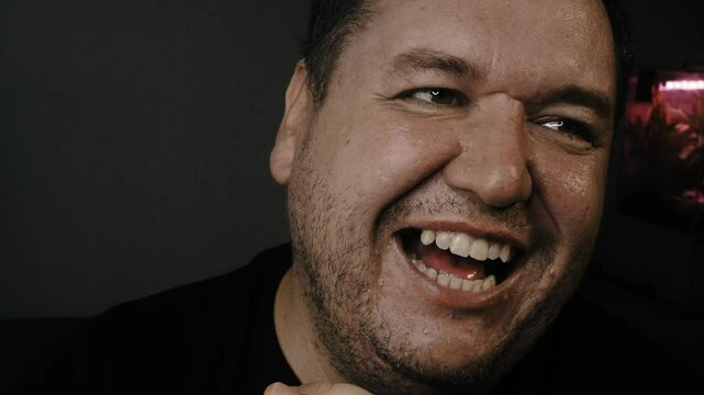 Cheerful man eats and watches TV.