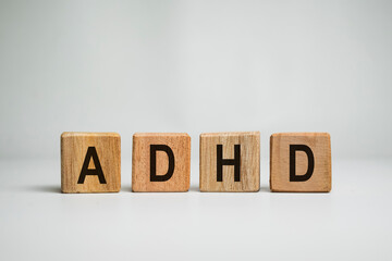 ADHD or attention deficit hyperactivity disorder text letter message on wooden cube isolated on white background