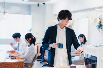 シェアオフィスでコーヒーを飲むビジネスマン