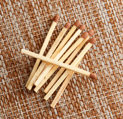 A pile of wooden matches with a red tip