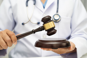 Doctor holding judge gavel, forensic medicine, medical law and crime justice.