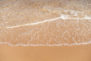 Soft waves wash gently onto a sandy beach in Egypt during a sunny afternoon in summer