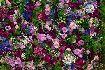 Lush floral display fills the backdrop with an exuberance of colors and textures, featuring diverse blooms and greenery, ideal for celebrations or decorative purposes.
