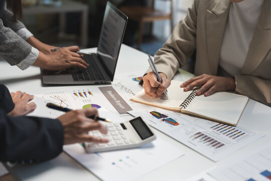 Professionals engaging in financial analysis, reviewing charts and graphs. Laptops and calculators on the table, emphasizing teamwork and data-driven decision-making in a business environment