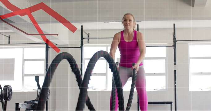 Image of diagrams over caucasian woman exercising at gym