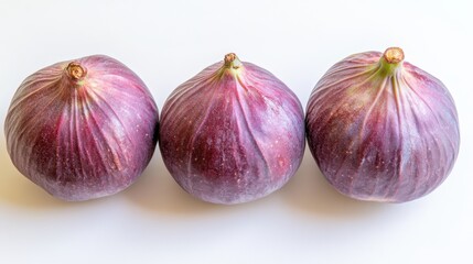 Obraz premium Three Fresh Purple Figs Arranged on a Light Background Showcasing Their Natural Texture
