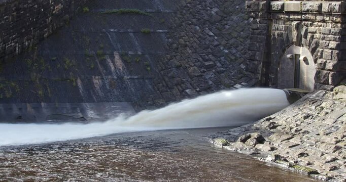 Side extra wide shot of the left water release valve releasing water at the Caban Coch Dam.