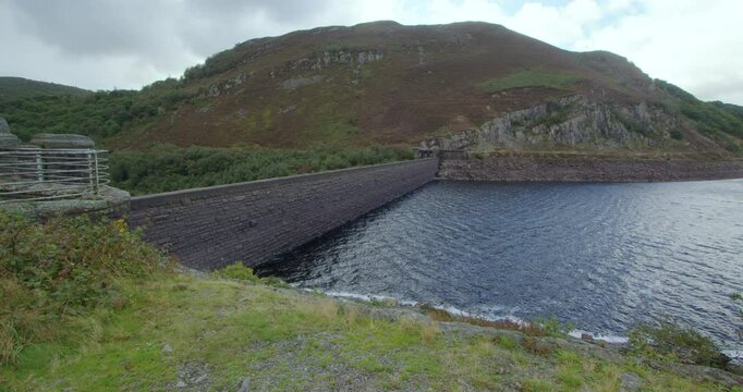 Extra wide shot looking at the upstream slope face of the Caban Coch Dam when partially drained