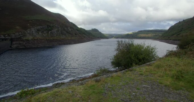 xtra Wide shot looking up the partially drained Caban Coch Reservoir next to the Caban Coch dam