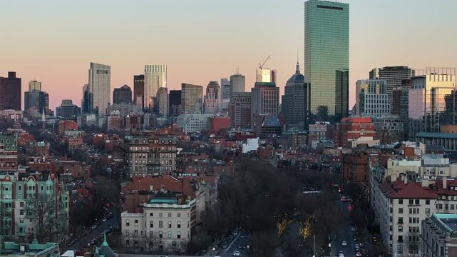Back Bay rooftops beneath downtown Boston skyline. Prudential Tower stands tall. Scenic vantage, aerial.