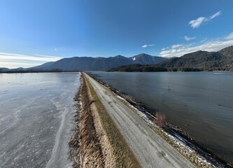 Gravel road between frozen lake and river