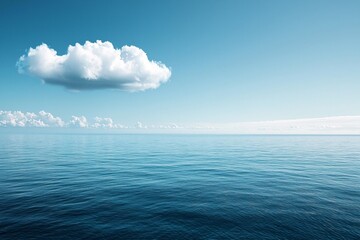 Obraz premium A vast, calm sea under the blue sky, with a white cloud in sky. The water is deep and serene, reflecting the clear sky above it. 
